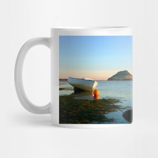 Classic style wooden clinker dinghy on beach. Mug